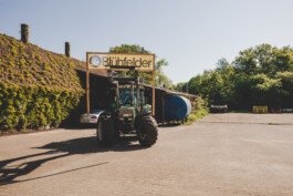 Ein Trecker, der einen Blühfelder-Banner transportiert